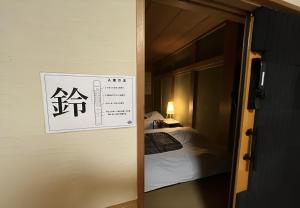 a room with a bed and a sign on the door at 鈴籠城 鈴の間 - ダブルベッド2台 - 最大4名 in Nagahama