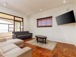 a living room with a couch and a flat screen tv at La Vue in Port Shepstone