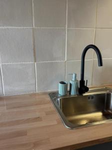 a kitchen sink with a faucet and two cups on it at Studio Juncalinho - Stylish Portuguese Studio in São Teotónio +52 photos