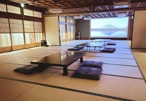 a large room with tables and a large screen at 鈴籠城 鈴の間 - ダブルベッド2台 - 最大4名 in Nagahama +8 photos