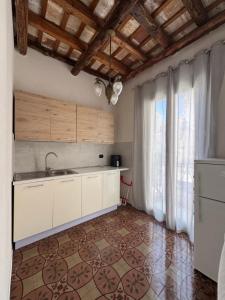 a kitchen with white cabinets and a large window at Marta House 2 in Trapani