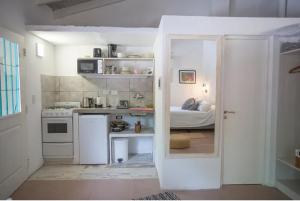 a small white kitchen with a bed in a room at Carumel in Villa Ciudad Parque