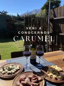 a table with two glasses of wine and food at Carumel in Villa Ciudad Parque