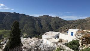 a house on a hill with mountains in the background at Camaraki Hill House Serifos in Serifos Chora