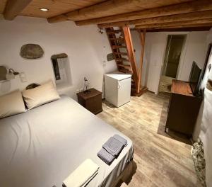 a bedroom with a white bed and a wooden floor at Camaraki Hill House Serifos in Serifos Chora