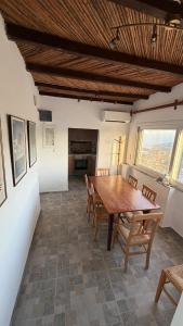 a dining room with a wooden table and chairs at Camaraki Hill House Serifos in Serifos Chora