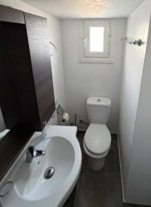a bathroom with a white toilet and a sink at Camaraki Hill House Serifos in Serifos Chora +11 photos