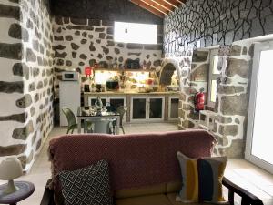 a living room with a couch and a stone wall at Xaminé in Água Retorta