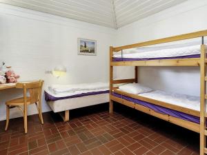 a room with two bunk beds and a desk at Coastal Bungalows with Beach Access in Karrebæksminde