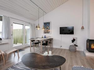 a living room with a table and a fireplace at Coastal Bungalows with Beach Access in Karrebæksminde