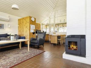 a living room with a fireplace and a table at Coastal Bungalows with Beach Access in Karrebæksminde