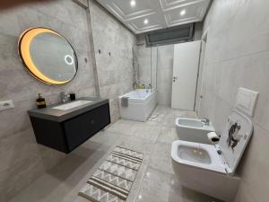 a bathroom with a sink and a toilet and a mirror at Il tramonto in Vlorë +22 photos