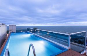 a swimming pool on top of a building with the ocean at Nautilus Apartment in Batumi