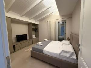 a bedroom with a large bed and a television at Il tramonto in Vlorë