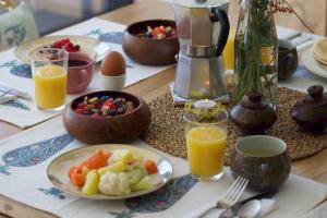 a breakfast table with a plate of food and orange juice at L'Effet Papillon - Maison d'hôtes in Sauges