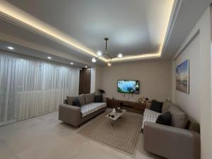 a living room with two couches and a tv at Il tramonto in Vlorë