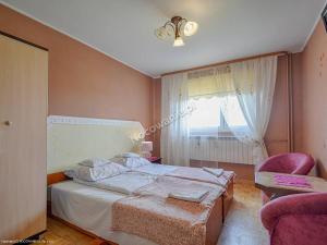 a bedroom with a bed and a chair and a window at Agroturystyka U Marty in Trzcinica +2 photos