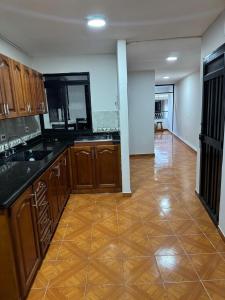 a kitchen with wooden cabinets and a tile floor at Casa del parque in Bello