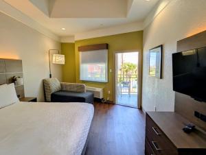 a hotel room with a bed and a flat screen tv at Holiday Inn Express & Suites Galveston West-Seawall by IHG in Galveston