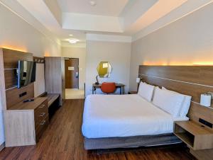 a hotel room with a bed and a television at Holiday Inn Express & Suites Galveston West-Seawall by IHG in Galveston +44 photos