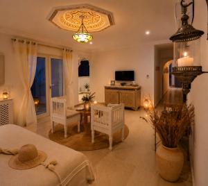 a bedroom with a bed and a table and chairs at DAR COLIBRI - Maison de charme à Kélibia in Kelibia