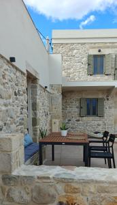 a patio with a table and chairs in front of a building at Ellotis Stone Retreat in Áyioi Dhéka