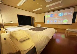 a hospital room with two beds and a projection screen at 鈴籠城 籠の間 - ダブル2台 二段ベッド1台 - 最大7名 in Nagahama