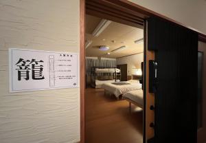 a room with two beds and a sign on the wall at 鈴籠城 籠の間 - ダブル2台 二段ベッド1台 - 最大7名 in Nagahama
