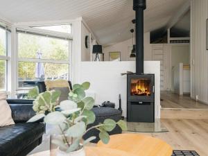 a living room with a couch and a fireplace at 5 star holiday home in Jerup in Jerup