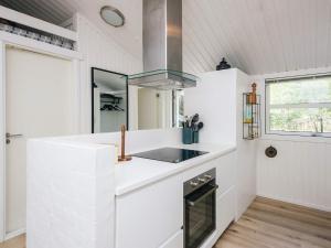 a white kitchen with a sink and a stove at 5 star holiday home in Jerup in Jerup
