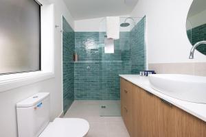 a bathroom with a sink and a toilet and a shower at Delightful Digs on David in Albury +6 photos