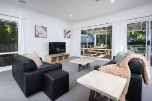 a living room with a couch and a tv at Delightful Digs on David in Albury