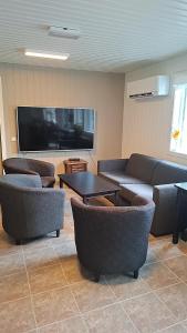 a living room with couches and a flat screen tv at Oppheim apartment, shared Pool & Sauna in Vossevangen