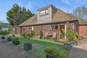 a house with a lawn with potted trees in front of it at 1 Bed in Alkham oc-s34788 in Swingfield