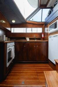 a kitchen with wooden cabinets and a sink and a window at Classic Seadream Yacht in Figueira da Foz