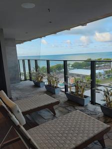 a balcony with a bench and a view of the ocean at New Time 304 Maceió Alagoas in Maceió
