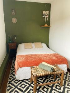 a bedroom with a bed with a bench on it at Onda Verde Hostel in San Salvador de Jujuy