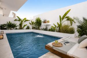 a swimming pool in the middle of a patio with plants at DAR COLIBRI - Maison de charme à Kélibia in Kelibia