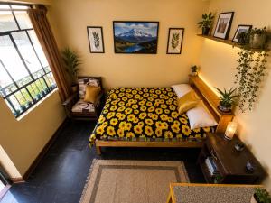a bedroom with a bed with a yellow blanket at CAYESH Guest House in Huaraz