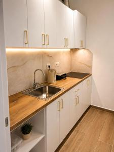 a kitchen with white cabinets and a sink at Vila Beqja in Durrës +24 photos
