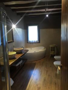 a large bathroom with a tub and two sinks at La Masia del Batlle in Sarroqueta