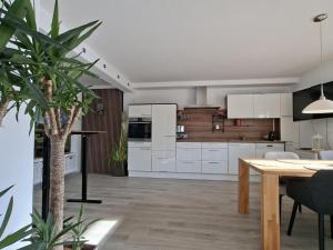 eine Küche mit weißen Schränken und einem Tisch darin in der Unterkunft Franziska in Schwoich