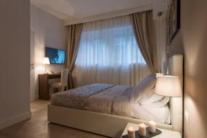 - une chambre avec un lit et une fenêtre avec des bougies dans l'établissement Aruna Suites, à Rome