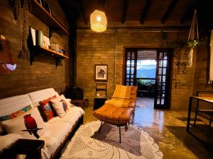 a living room with a couch and a chair at Sítio Passarim in São Francisco Xavier