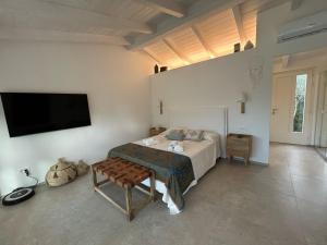 a bedroom with a bed and a flat screen tv at Exclusive Villa Aurea with private pool in Cugnana