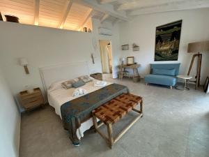 a bedroom with a bed and a blue chair at Exclusive Villa Aurea with private pool in Cugnana +15 photos