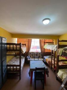 a dorm room with bunk beds and a table and a table sidx sidx at CAYESH Guest House in Huaraz +6 photos