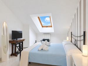 a bedroom with a blue bed with a skylight at Cà di Lilly - Attic Suite AC Wi-Fi in Vado Ligure