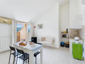 a kitchen and living room with a table and chairs at Cà di Lilly - Attic Suite AC Wi-Fi in Vado Ligure