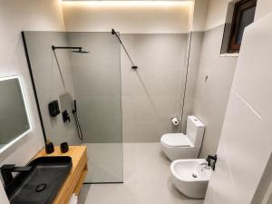 a bathroom with a sink and a toilet and a shower at L olive Villa in Zogaji +29 photos